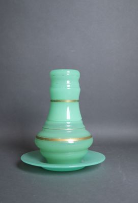 un vase vert posé sur une soucoupe