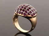 a close up of a gold ring with red and white stones