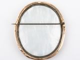 a round mirror on the wall with a metal bar