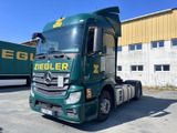 un camion vert garé devant un immeuble