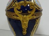 a blue and gold vase with a gold decoration on it
