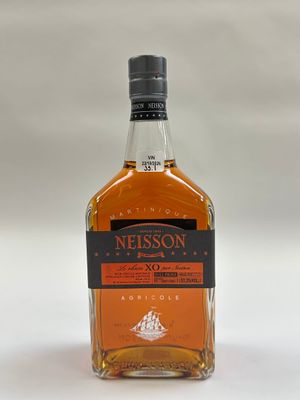 un gros plan d'une bouteille de whisky posée sur une surface blanche