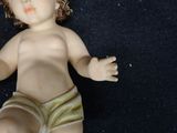 a baby doll with a diaper on a black surface