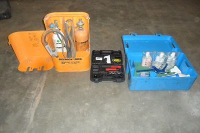 trois cartons contenant différents types de matériel électrique, posés par terre