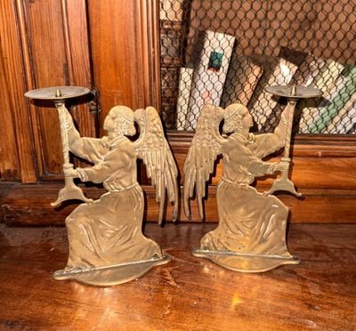 deux figurines d'anges posées sur une table devant une fenêtre