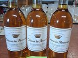 trois bouteilles de vin posées sur une table en bois