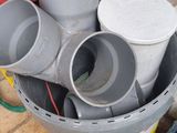 a bucket full of different types of pipes on the floor