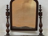 a mirror sitting on top of a table next to a wall