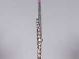a flute that is sitting on a stand in front of a gray wall