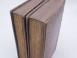 three books stacked on top of each other on a white surface