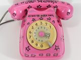a pink telephone with stars on it on a white surface