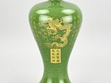 a green vase with a gold dragon on it
