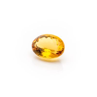 a yellow sapphire stone on a white background