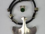 an image of a necklace with a green stone on a black cord