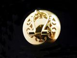 a close up of a gold clock on a black surface