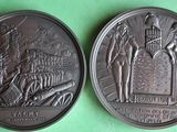 two bronze medallions depicting a scene of a man and woman on a stage