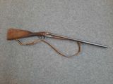 a rifle with a wooden handle and a leather sheath
