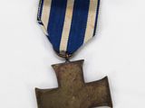an old medal with a cross on a blue and white ribbon