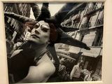 a black and white photo of a woman with a bird on her head
