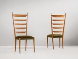 deux chaises en bois aux assises rembourrées de vert, adossées à un mur blanc