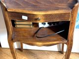 une petite table en bois avec un tiroir et un téléphone posé dessus