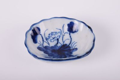 un petit bol bleu et blanc orné de fleurs