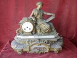 a statue of a woman sitting on top of a clock