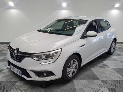 la voiture blanche est garée sur un sol en damier dans le garage