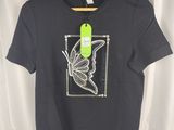 a black shirt with a butterfly on the front and a green tag on the back