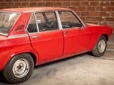 a red car that is parked in front of a brick wall