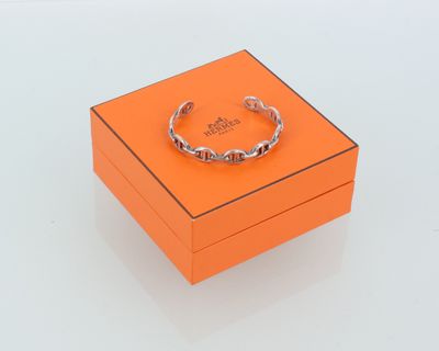 une boîte orange contenant un anneau, posée sur une surface blanche