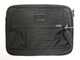 une valise noire posée sur une surface blanche