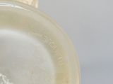 un gros plan d'un vase blanc muni d'une anse marron