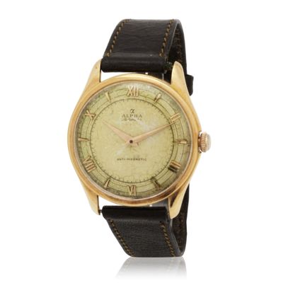 a gold plated wrist watch with roman numerals on a black leather strap