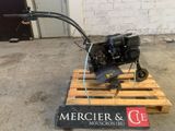 un petit moteur posé sur une palette en bois dans un garage