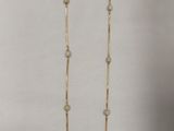 un gros plan d'un collier en or orné de perles sur fond blanc