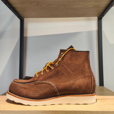 un gros plan sur une paire de bottes marron posées sur une étagère