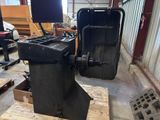 a black machine that is sitting on a pallet in a warehouse
