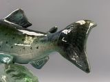 une statue représentant un poisson assis sur un rocher
