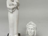 une statue représentant une femme tenant un bébé dans ses bras et un buste de femme