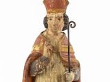 an old wooden statue of a man with a cane and a hat