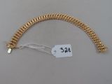 un bracelet en or sur lequel est accrochée une étiquette de prix