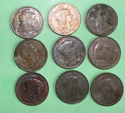 six different types of coins are shown on a green surface