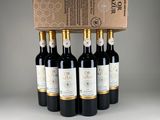 four bottles of wine in a cardboard box on a table