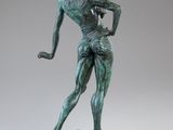 a bronze statue of a woman with a hat on her head