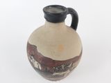 a brown and black vase sitting on a white surface