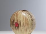 a small wooden object with a red dot on it
