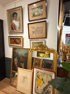 Il y a de nombreux tableaux encadrés accrochés au mur dans cette pièce.