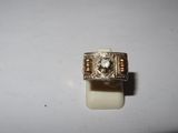 a close up of a ring with a diamond in it on a white surface
