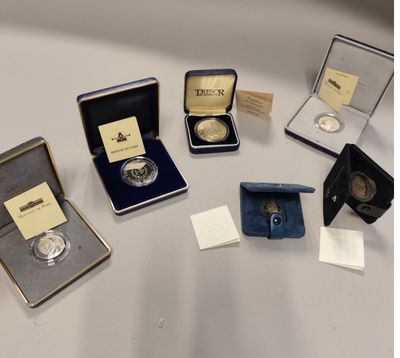 several different types of silver coins are on display on a table